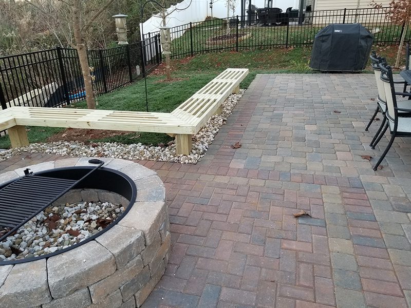 Citywide Fence & Deck Fort Mill SC | paved patio with fire pit and bench and iron fence